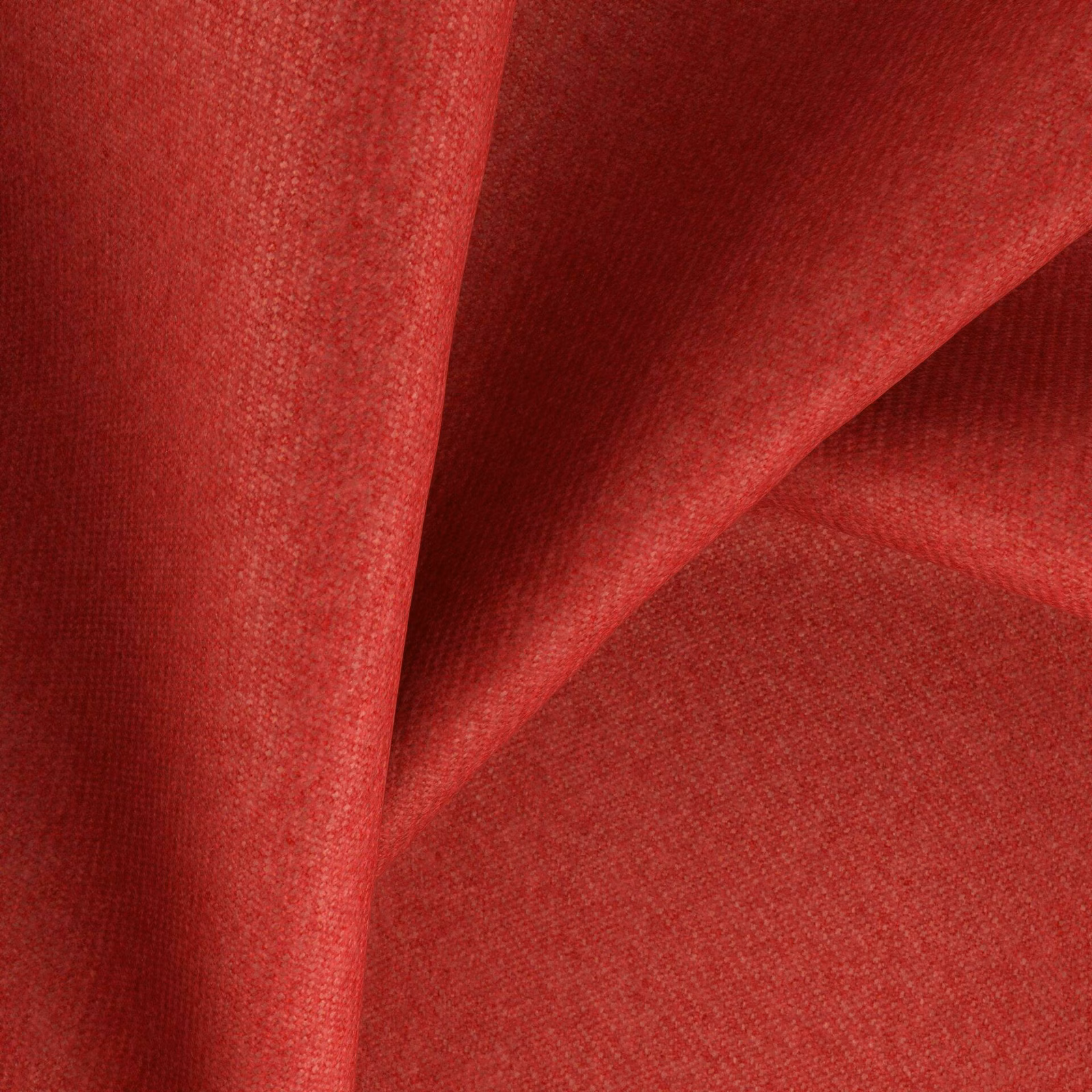 Saturated tomato-red woven fabric folded to reveal fine texture and burgundy shadows