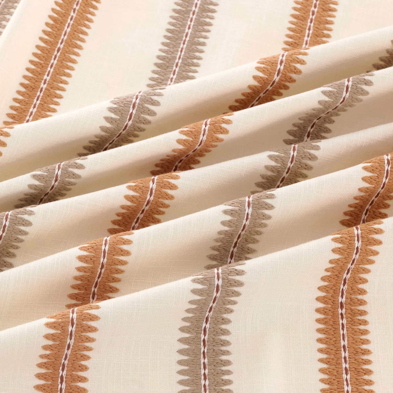 Cream woven textile with rust and taupe leafy vertical stripes, folded in soft pleats.