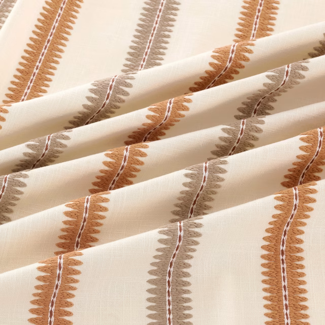 Cream woven textile with rust and taupe leafy vertical stripes, folded in soft pleats.