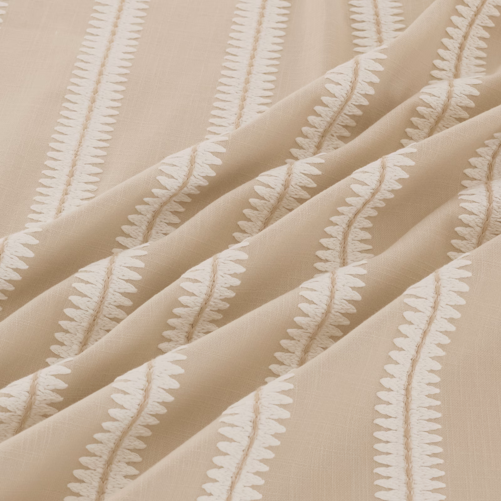 Warm taupe fabric with raised ivory leafy stripes falling in soft folds