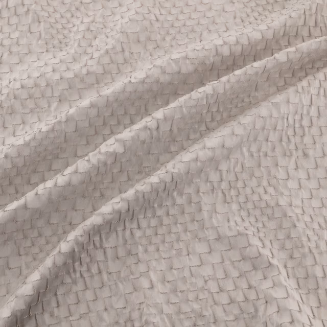 Cool silver-grey fabric with a small raised scale-like woven texture in soft folds
