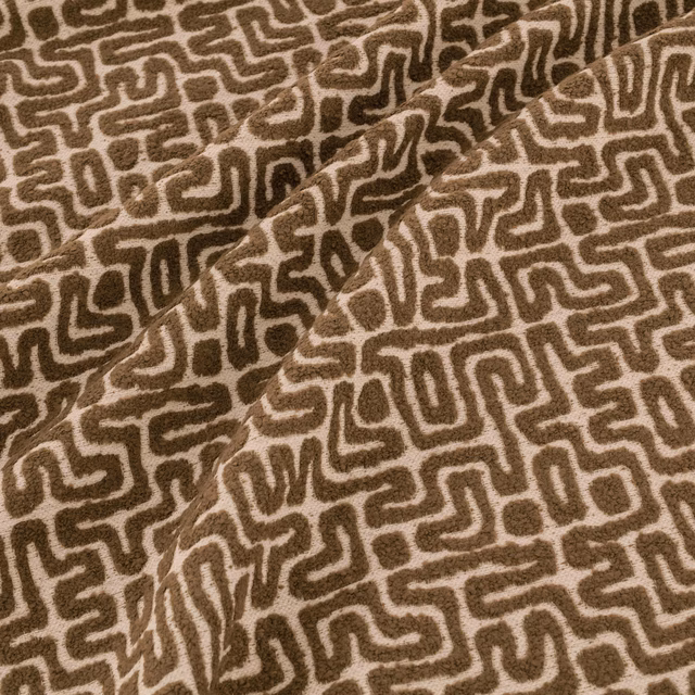 Warm earth-brown fabric with cream maze-like lines and softly textured folds