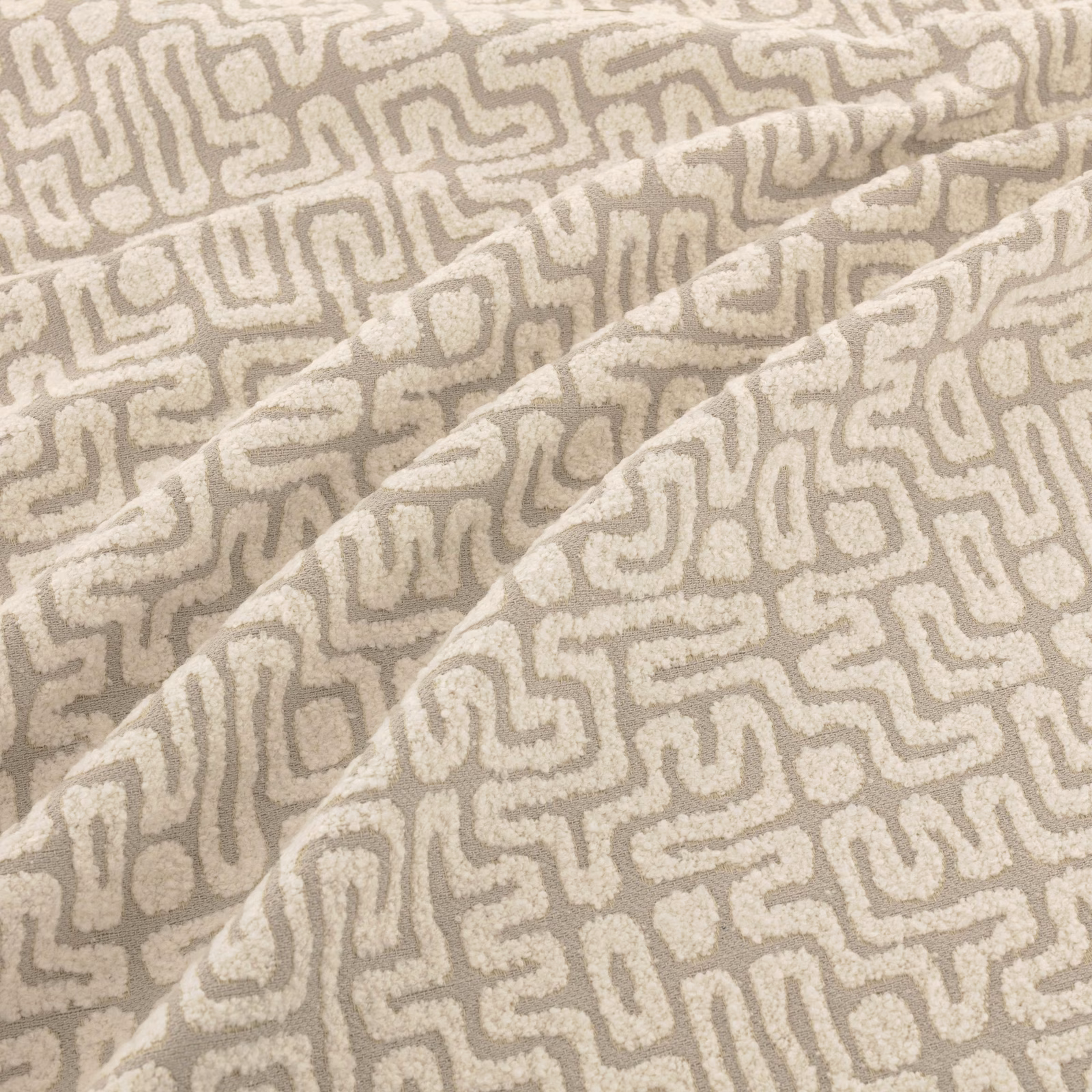 Warm greige taupe woven swatch with raised ivory maze-like lines and soft folds