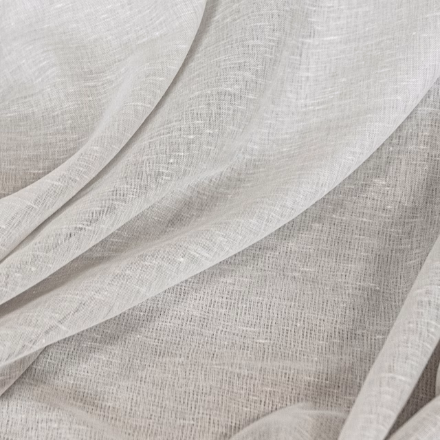 Soft ivory open-weave textile draped in overlapping folds with subtle grey shadowing