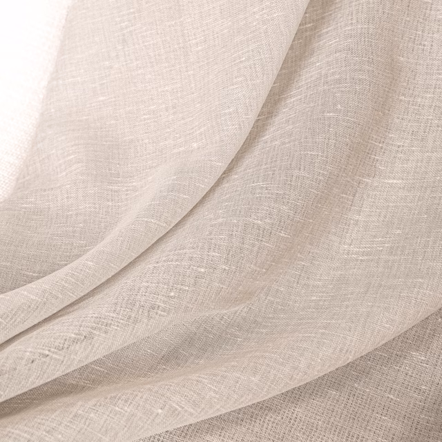 Pale natural fabric with fine crosshatch weave draped in overlapping translucent folds