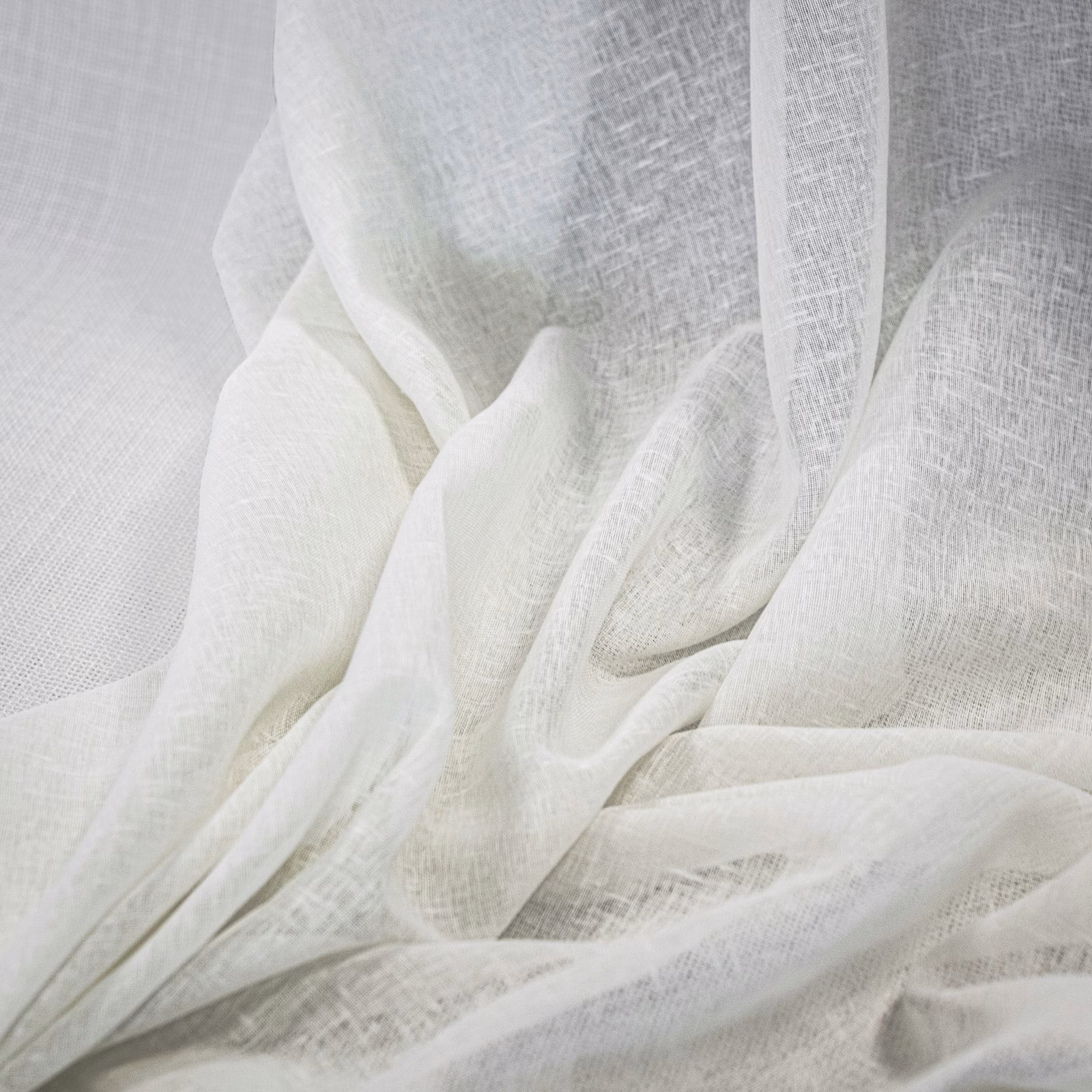 Sheer ivory-white open weave gathered into softly translucent folds