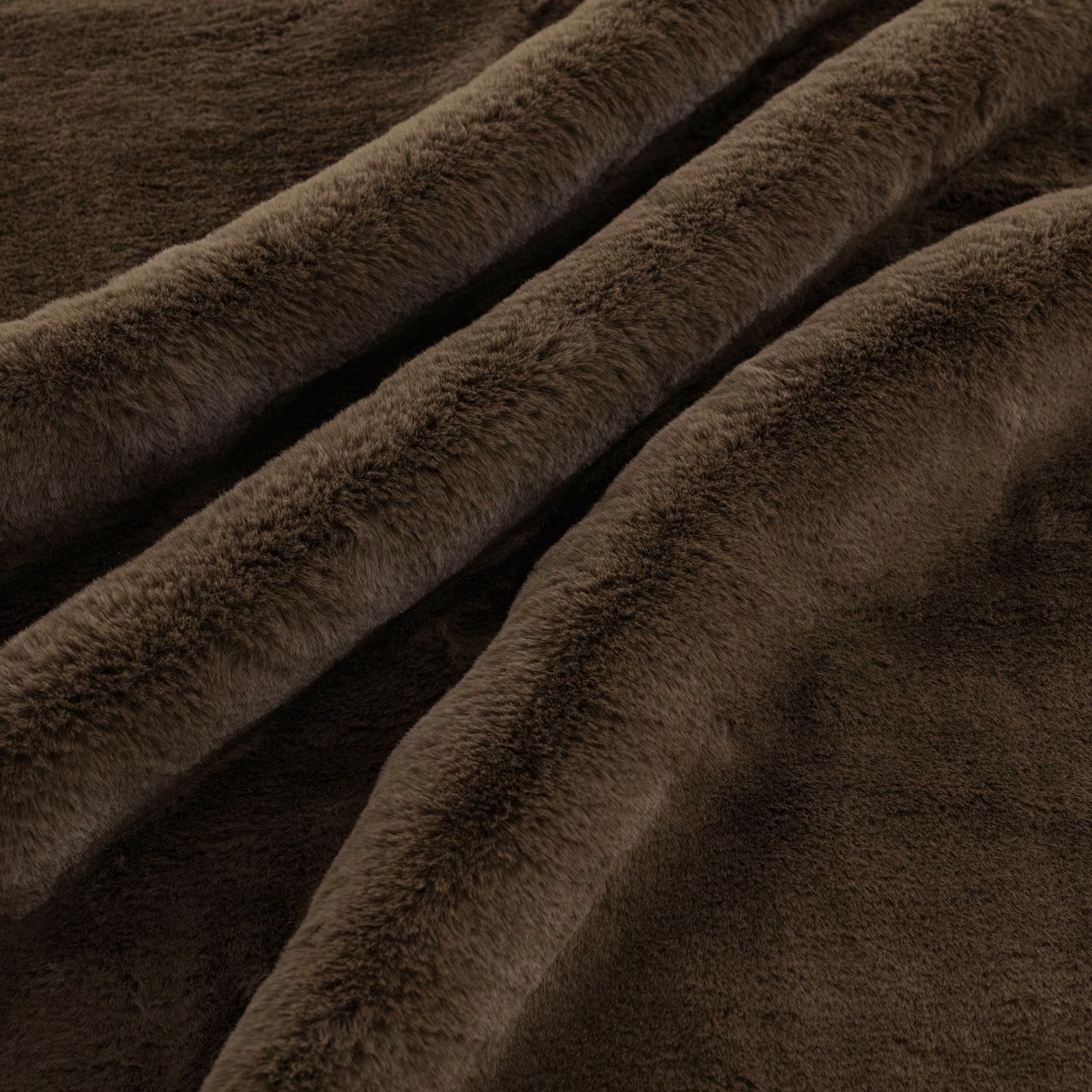Deep chestnut-brown plush pile fabric gathered into softly shadowed folds