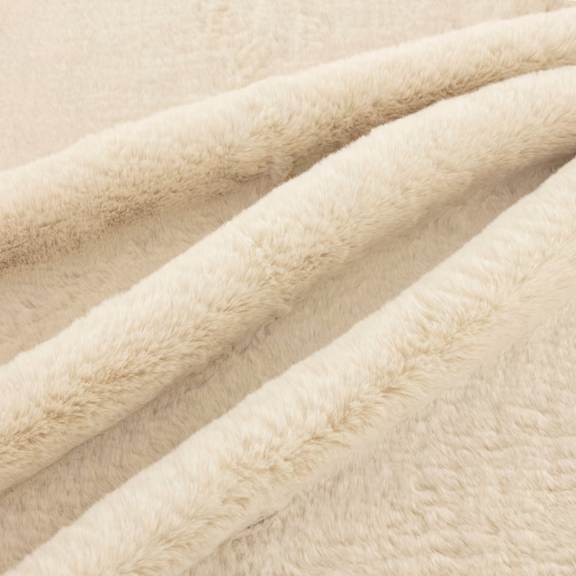Warm ivory plush pile with soft directional nap visible across folded swatch