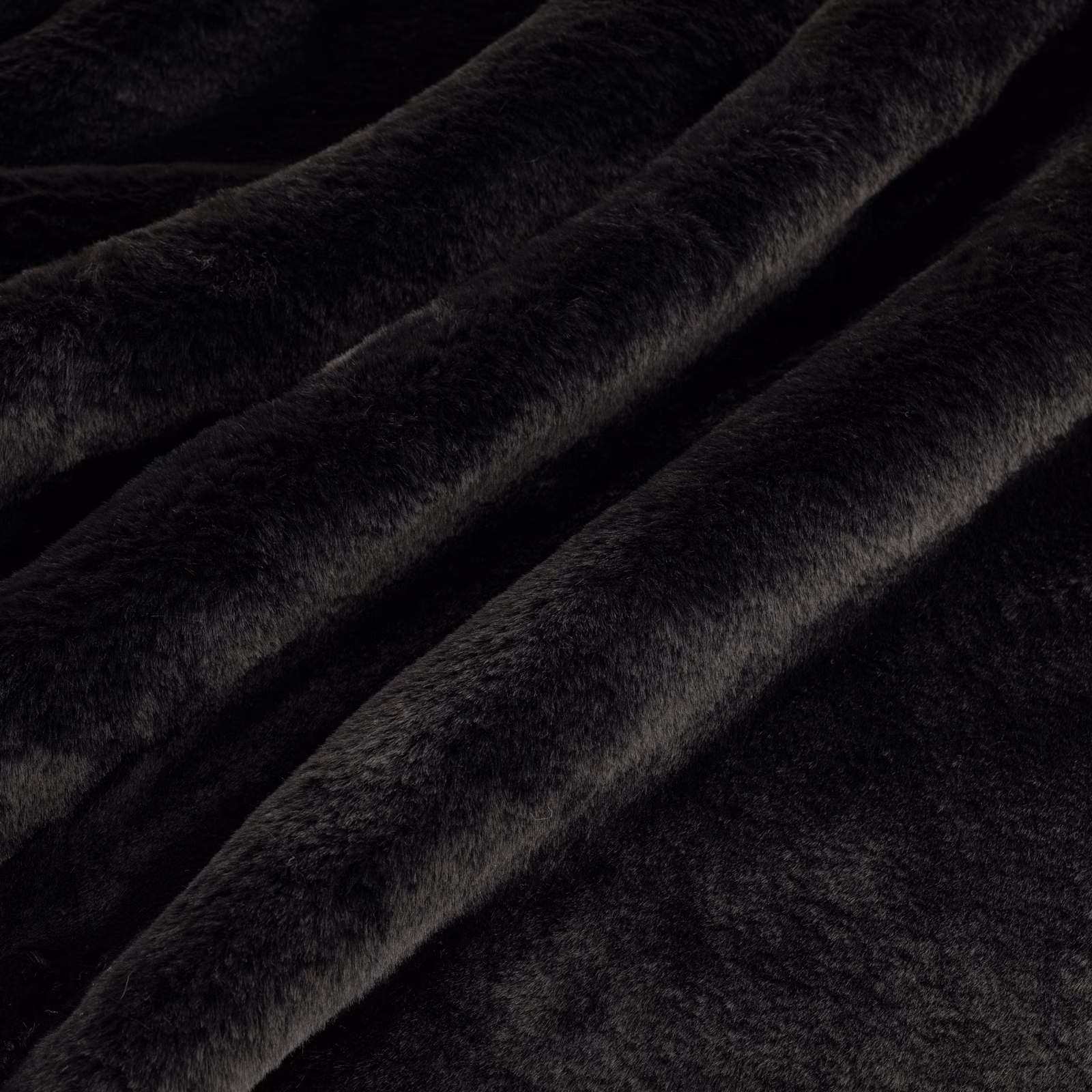 Deep black plush pile fabric with softly catching highlights across folded ridges