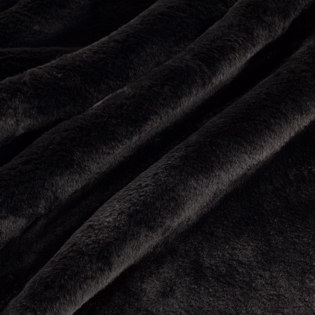 Deep black plush pile fabric with softly catching highlights across folded ridges