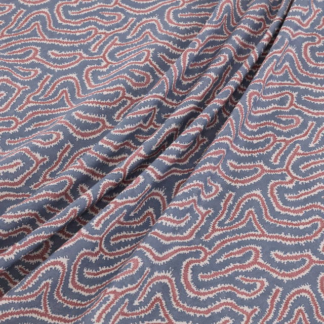 Dusty blue woven paisley fabric with ivory and muted red details in soft folds