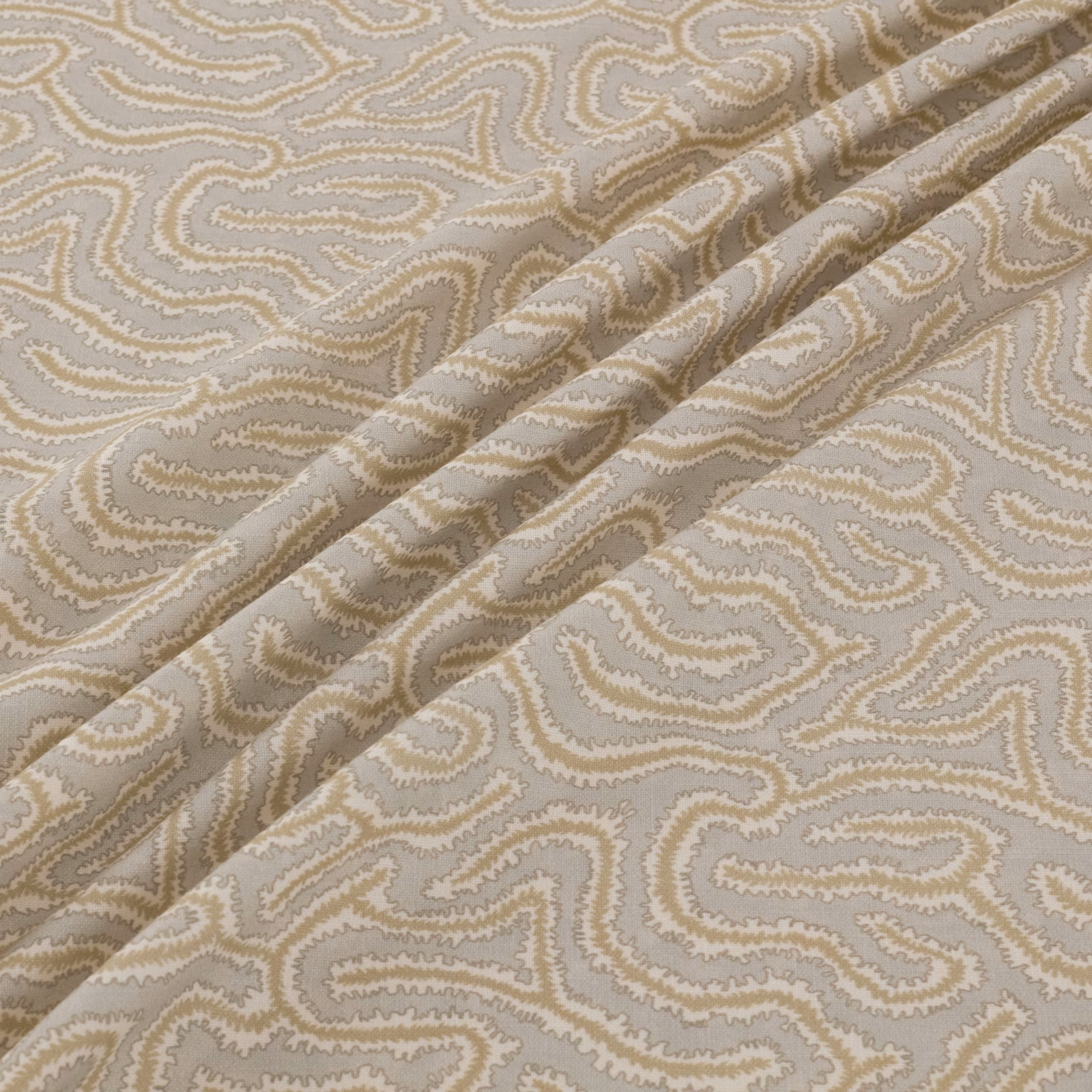 Warm taupe and cream scrolling paisley-like weave shown in a folded swatch