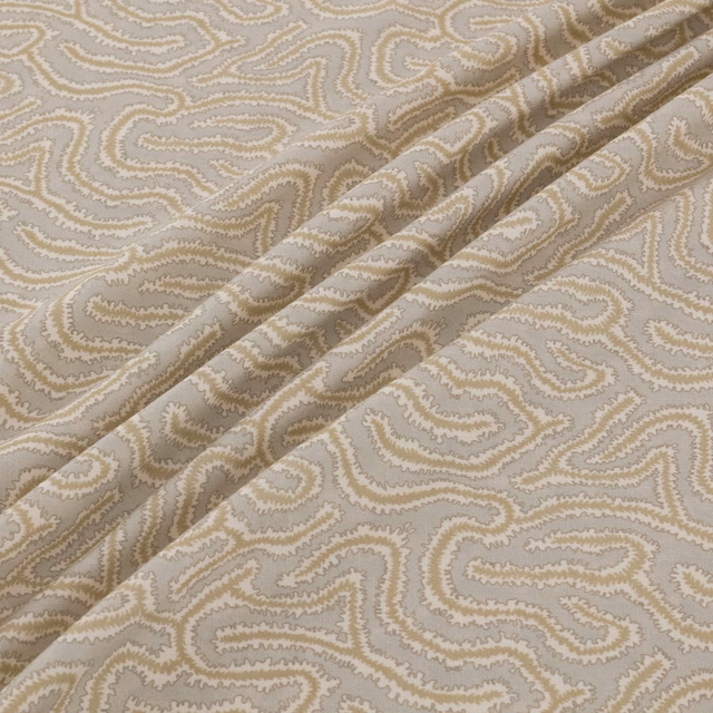 Warm taupe and cream scrolling paisley-like weave shown in a folded swatch