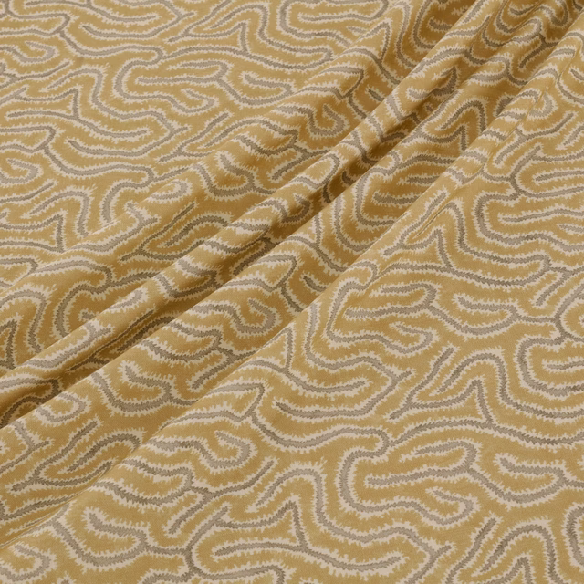 Ochre-gold woven fabric with cream sinuous motifs and softly folded texture