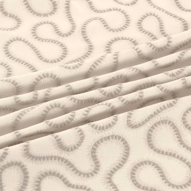Ivory fabric with soft dove-grey looping motifs and a lightly textured weave in folded layers