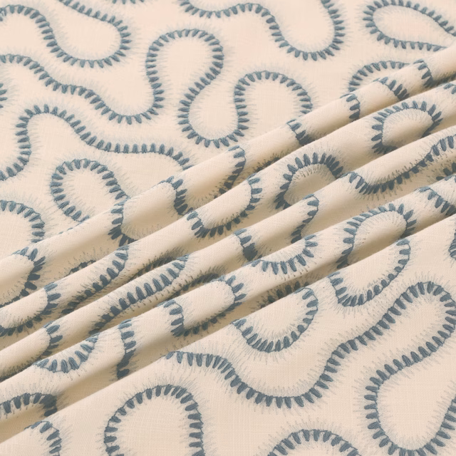 Cream woven fabric with cool blue-grey looping motifs and soft folded texture