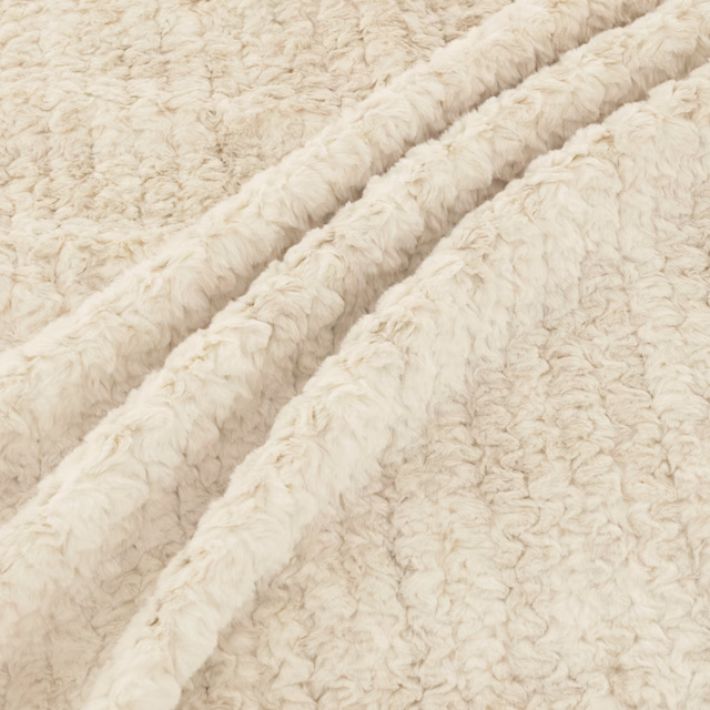 Warm ivory cream fabric with shaggy curly pile gathered into deep soft folds