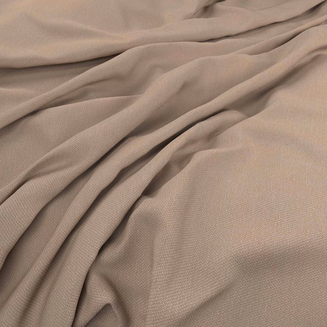 Warm desert taupe fabric with fine woven texture arranged in soft flowing folds