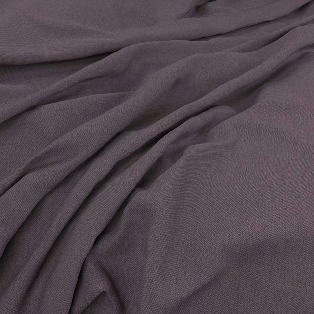 Dusky mauve-grey woven fabric draped in softly shadowed folds
