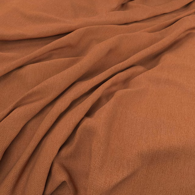 Warm henna terracotta woven fabric gathered into softly shadowed fluid folds