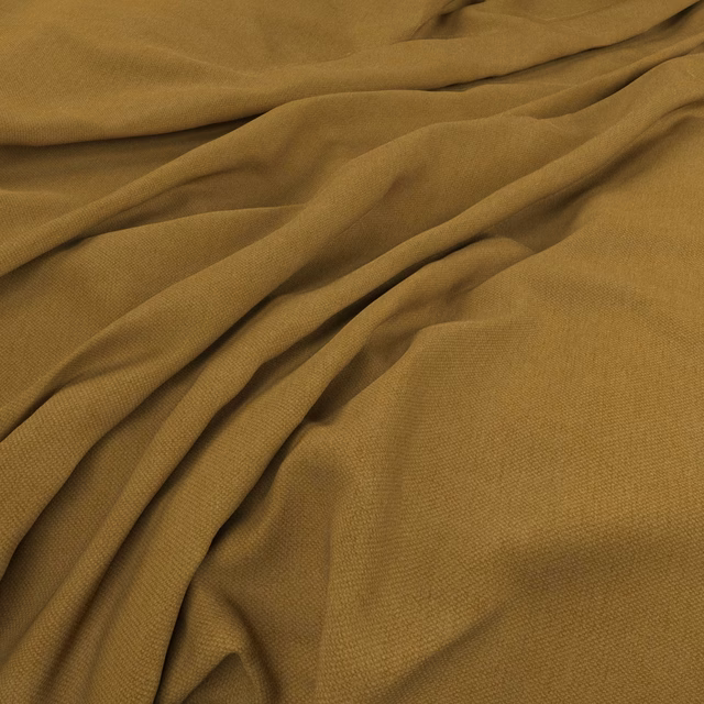 Warm ochre plain weave fabric gathered into soft, fluid folds