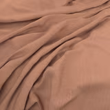 Muted peony-pink plain weave fabric gathered into soft, flowing folds