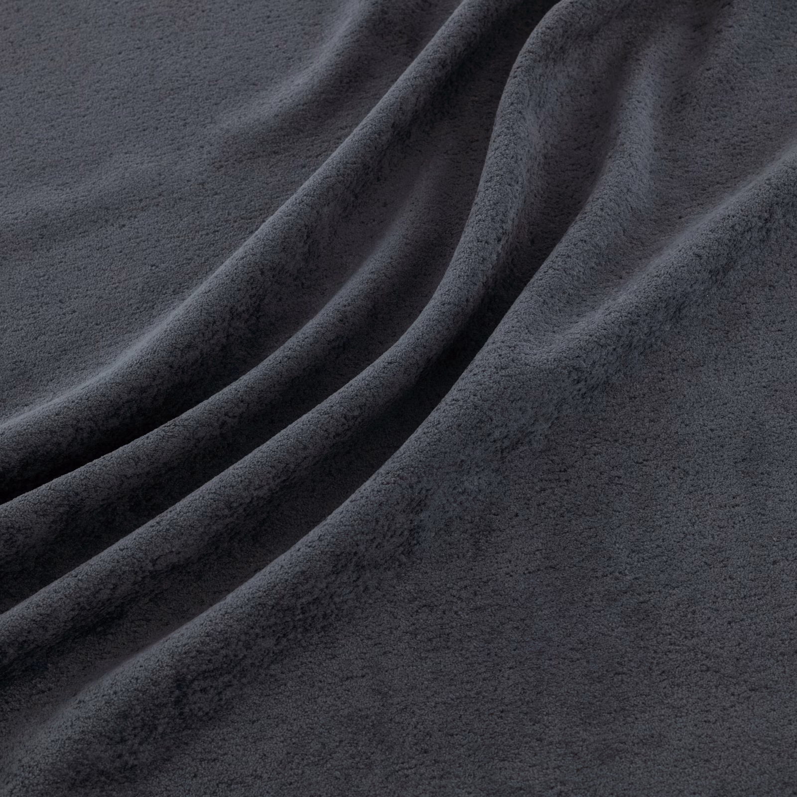 Deep charcoal-indigo fabric with a soft brushed surface falling in broad folds