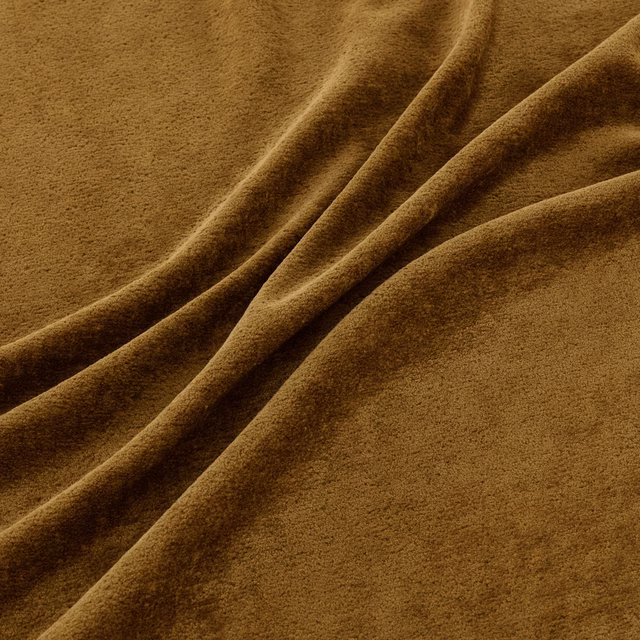 Warm saffron-brown plush pile fabric gathered into softly catching folds