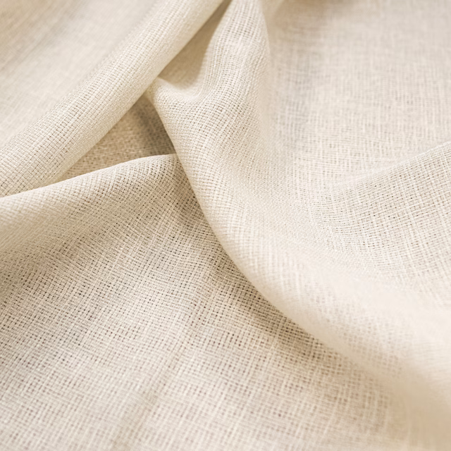 Warm ivory open-weave textile draped in soft folds with a fine crosshatched surface