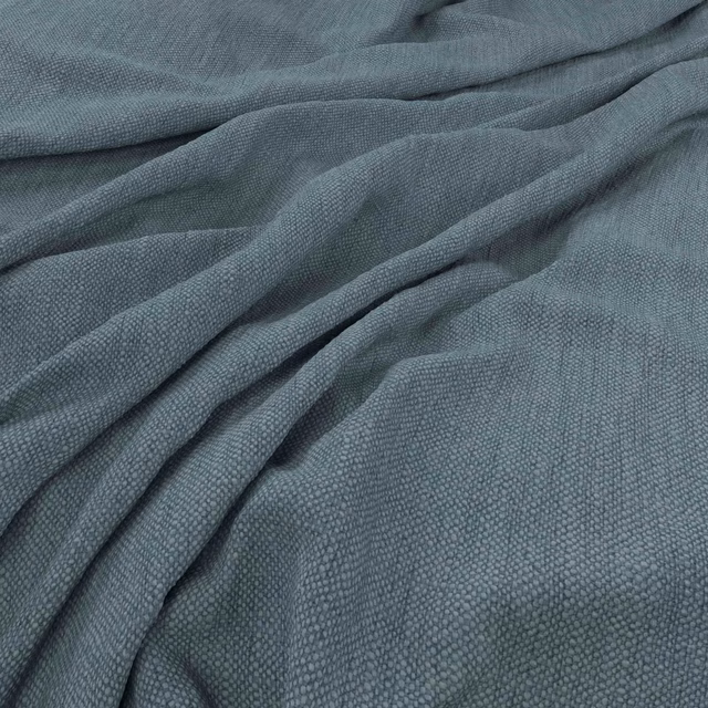 Muted blue-grey woven textile with fine pebbled texture arranged in soft folds