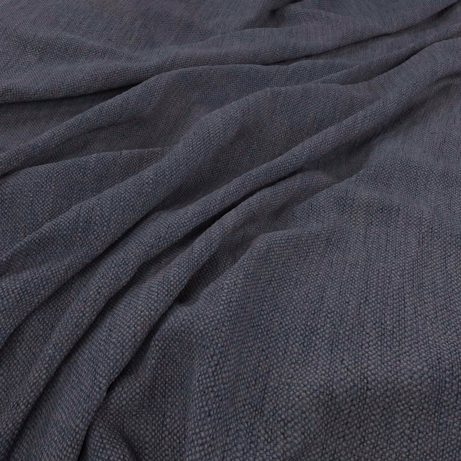 Close-up of dark denim blue-grey fabric with fine pebbled weave in gathered folds