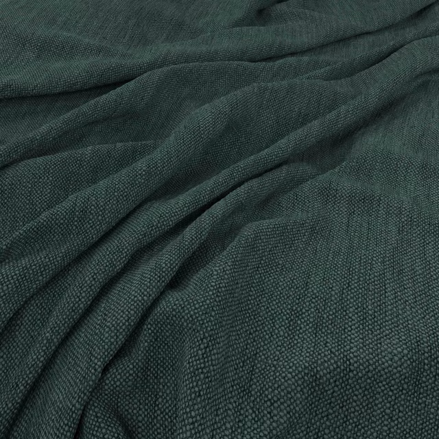 Deep pine-green woven swatch with fine pebbled texture gathered into soft folds