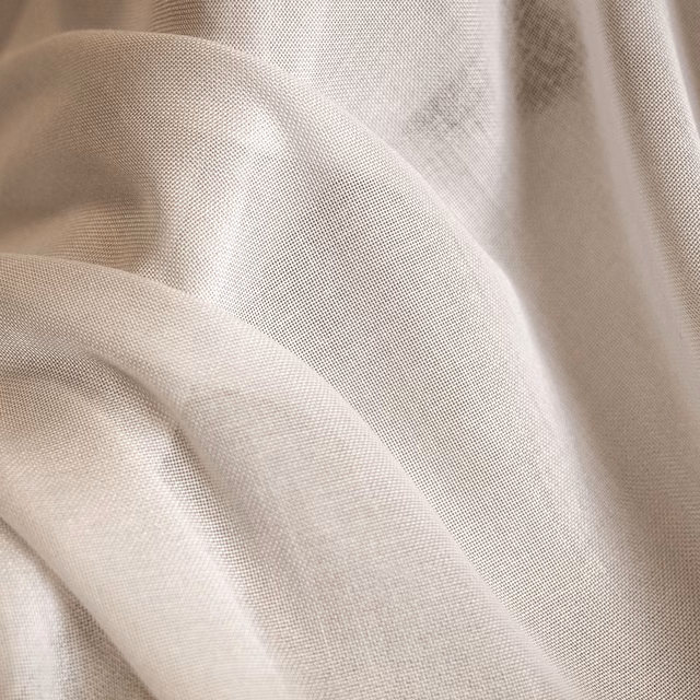 Warm cream finely woven fabric draped in soft folds with a subtle ivory sheen
