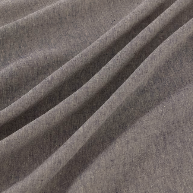 Muted denim blue-grey woven fabric with soft striations in diagonal folds