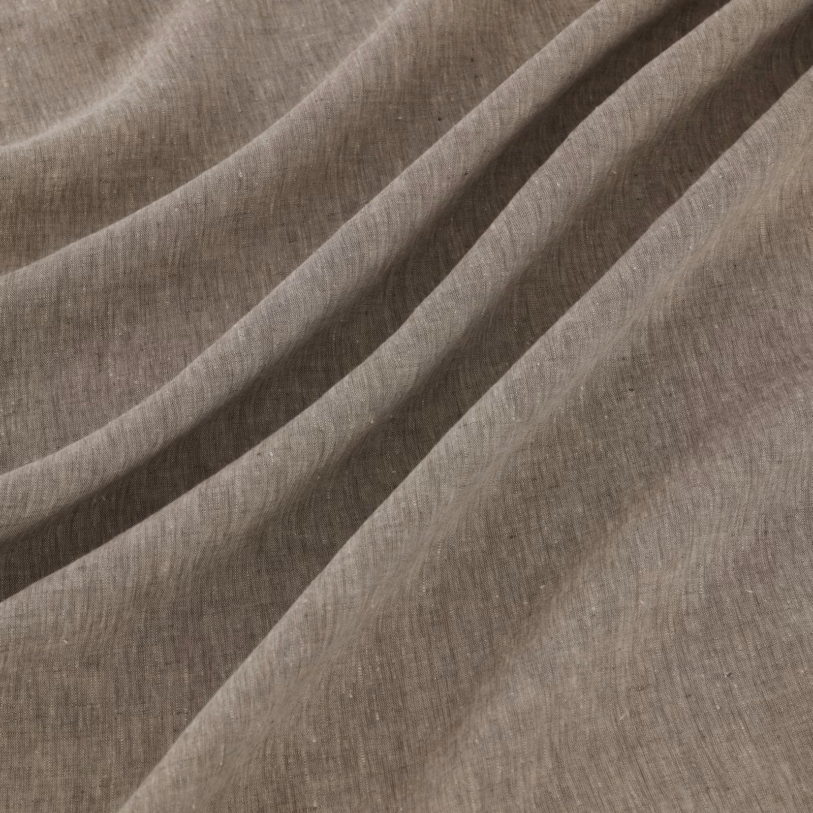 Graphite-grey slubbed textile gathered into soft, fluid diagonal folds