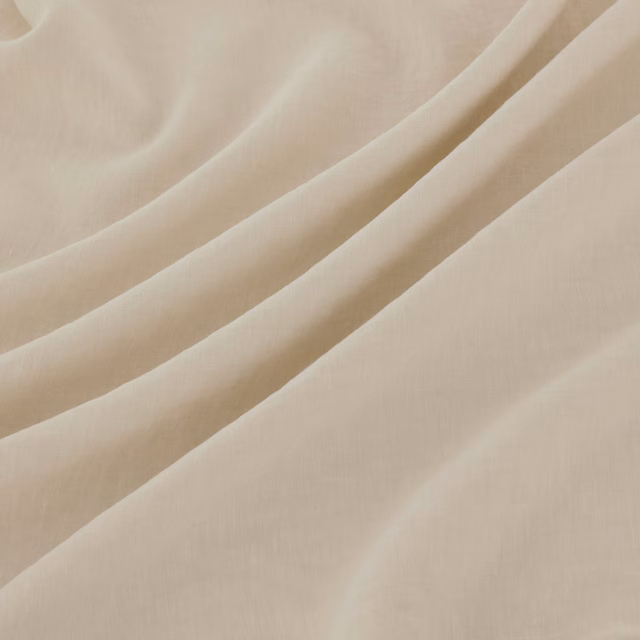 Warm ivory finely woven fabric falling in softly gathered diagonal folds