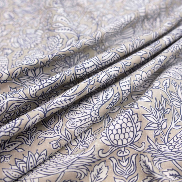 Warm corn-silk fabric with navy paisley, botanical motifs and softly folded texture