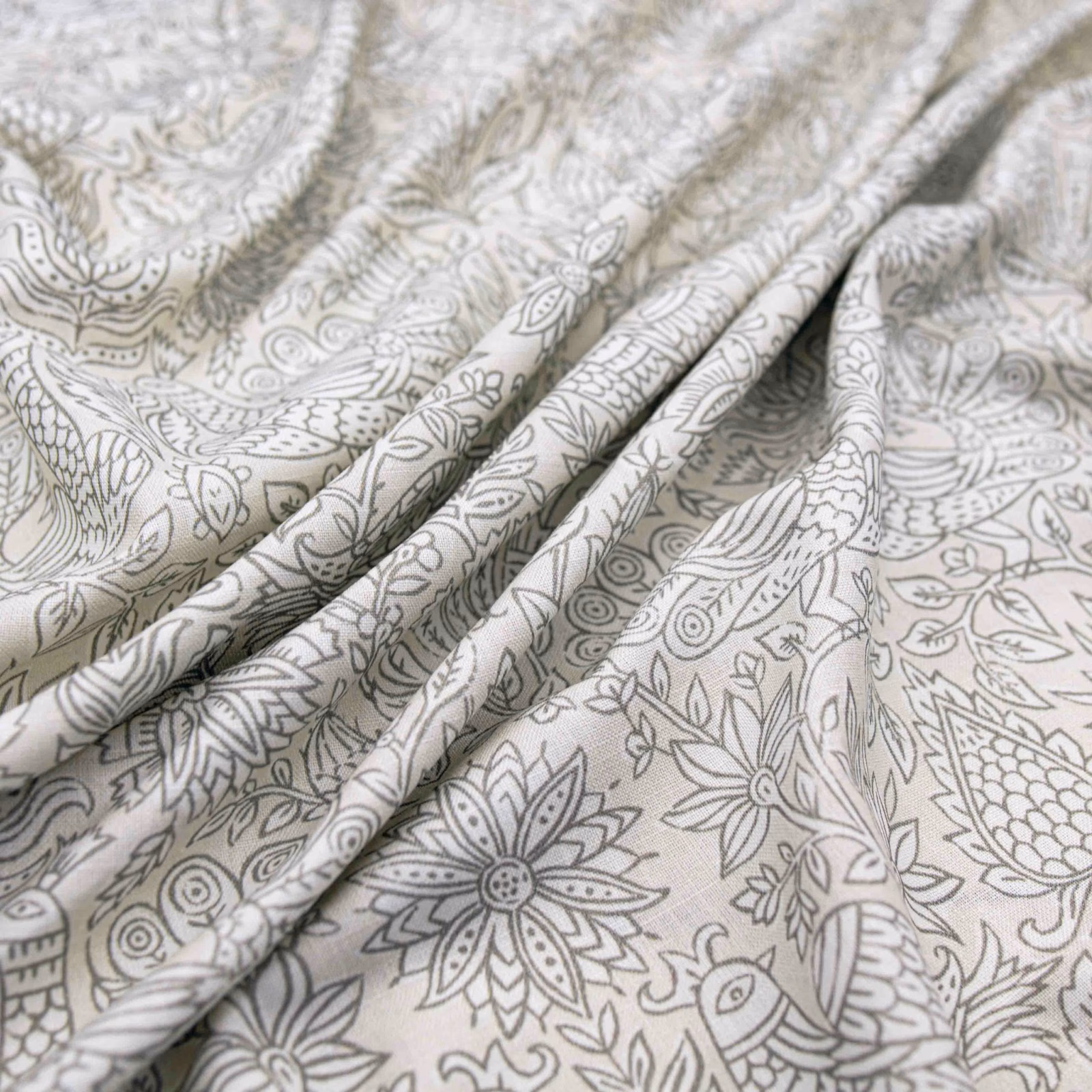 Pale putty fabric with grey botanical, floral and bird linework in soft folds