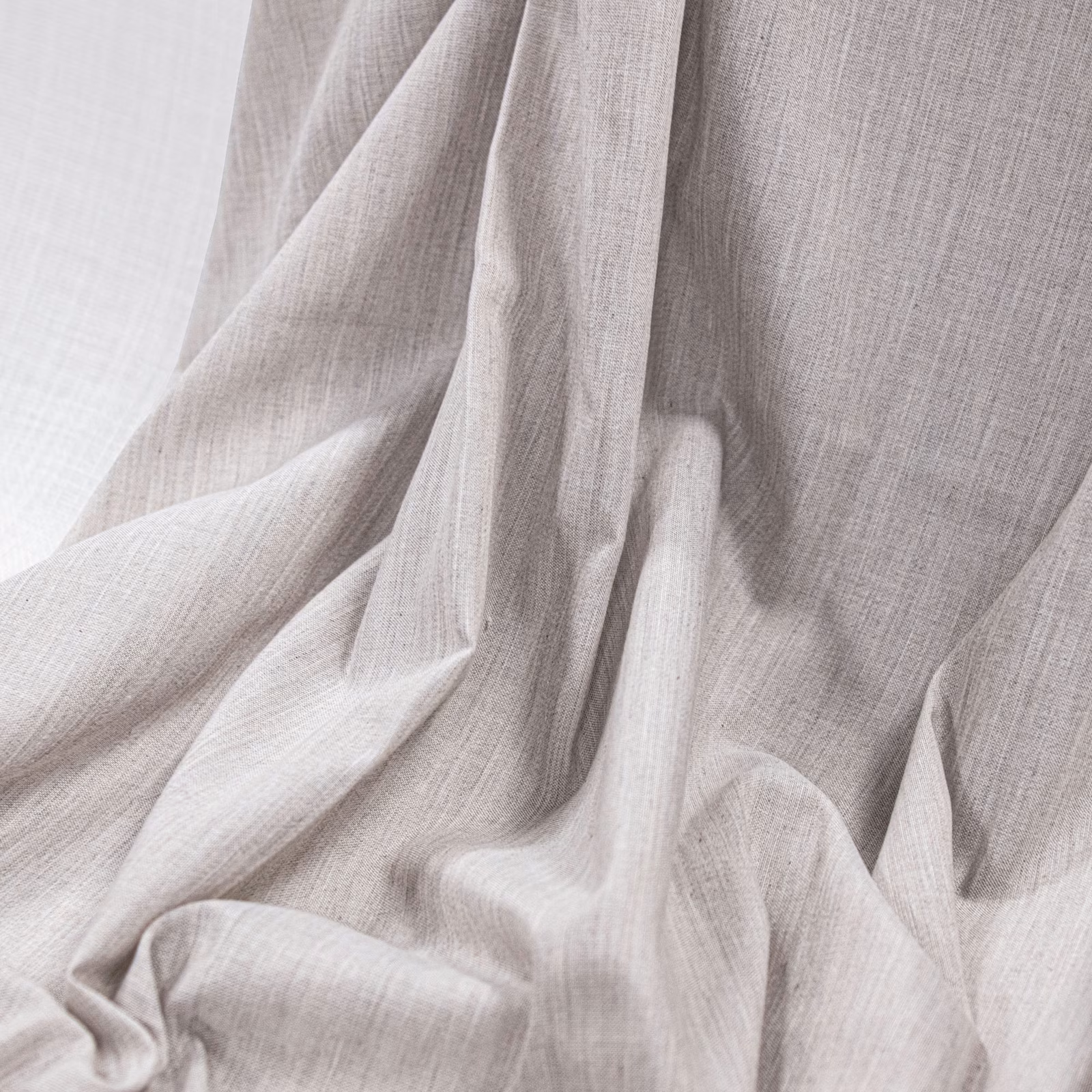 Pale natural-beige fabric with fine crosshatched weave in soft gathered folds