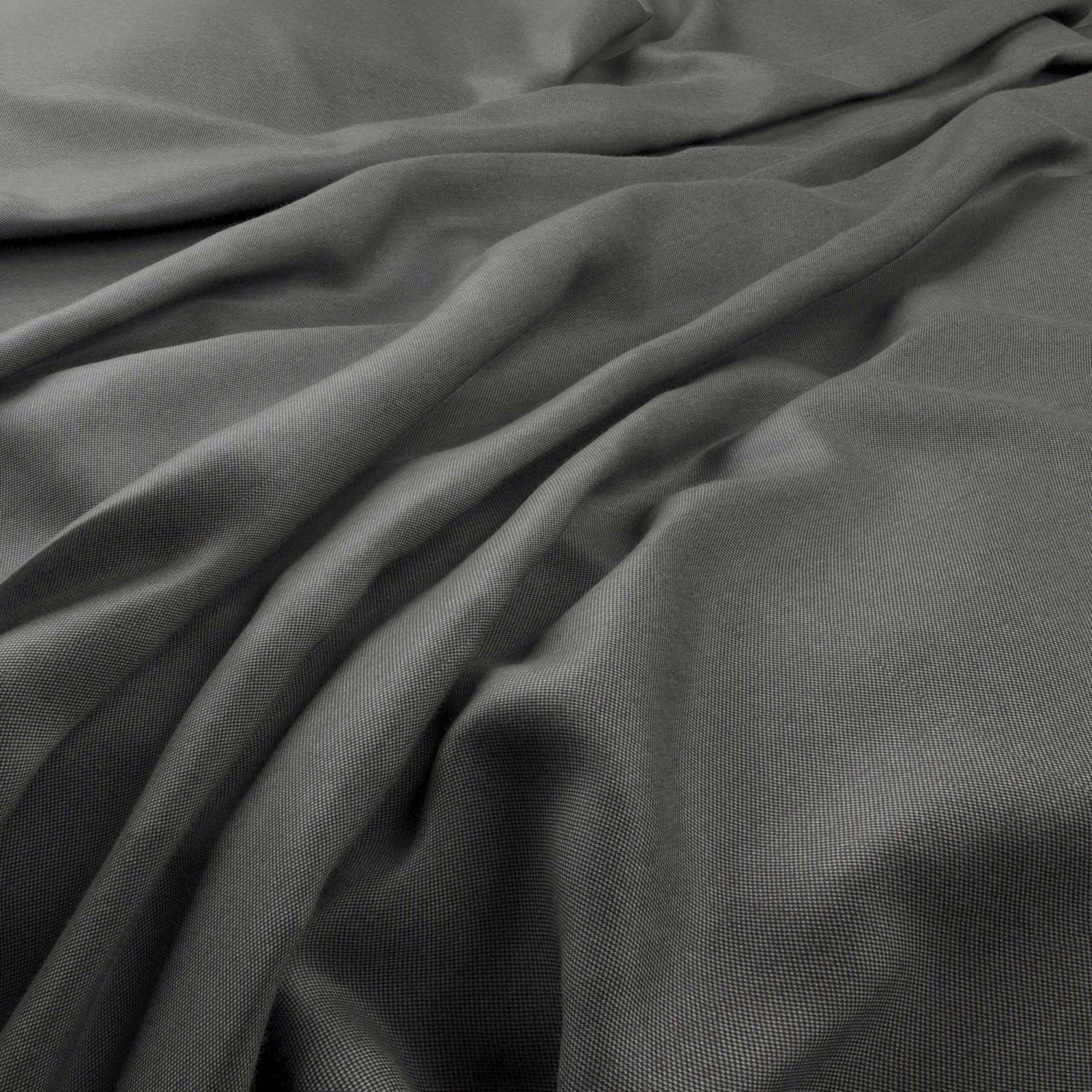 Deep charcoal-grey plain weave fabric gathered into soft, shadowed folds