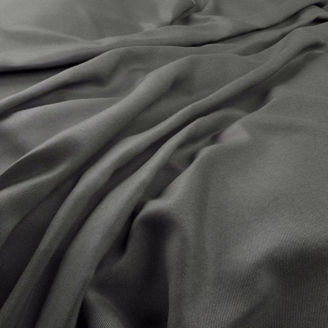 Deep charcoal-grey plain weave fabric gathered into soft, shadowed folds