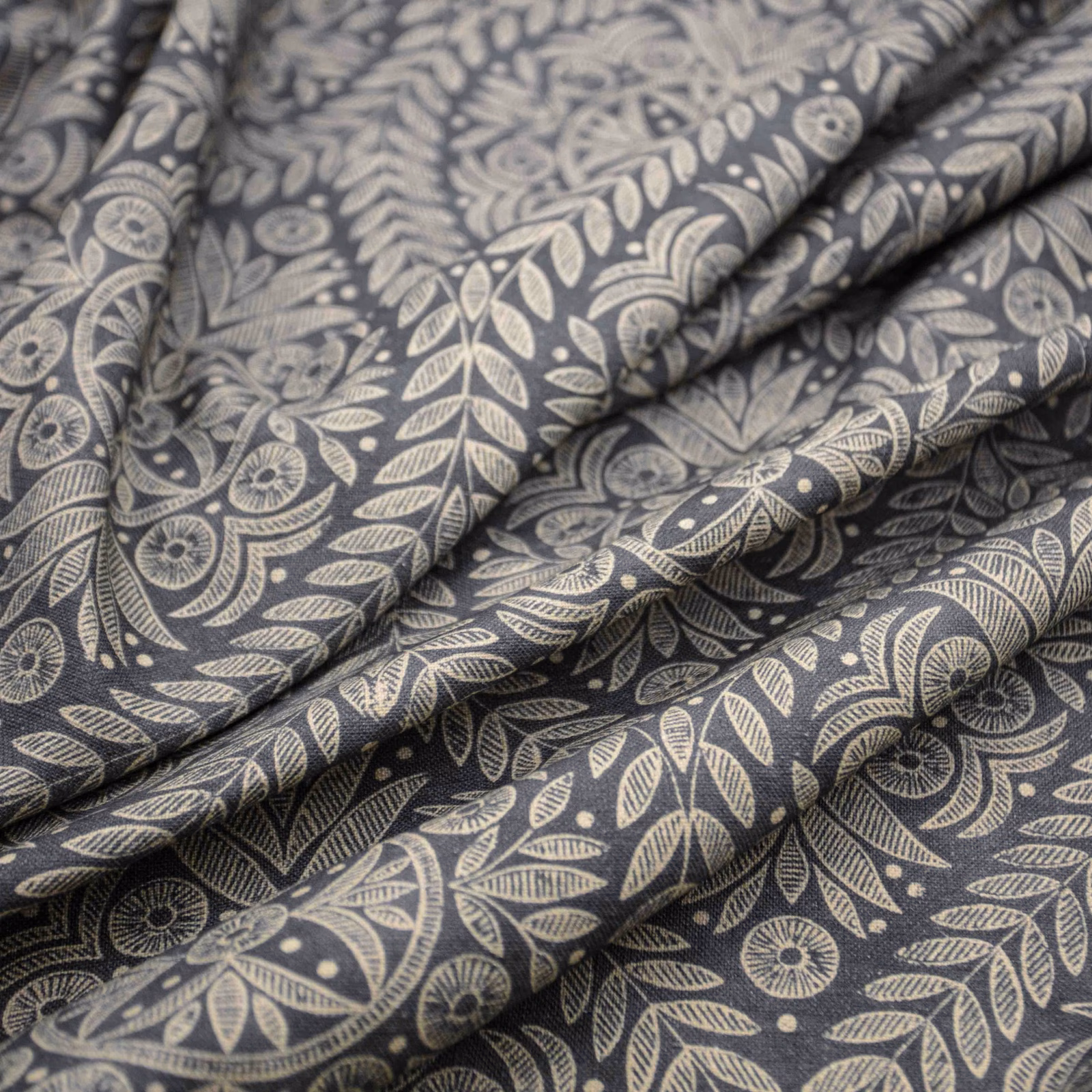 Charcoal fabric with pale stone botanical leaves and stylised flowers in soft folds
