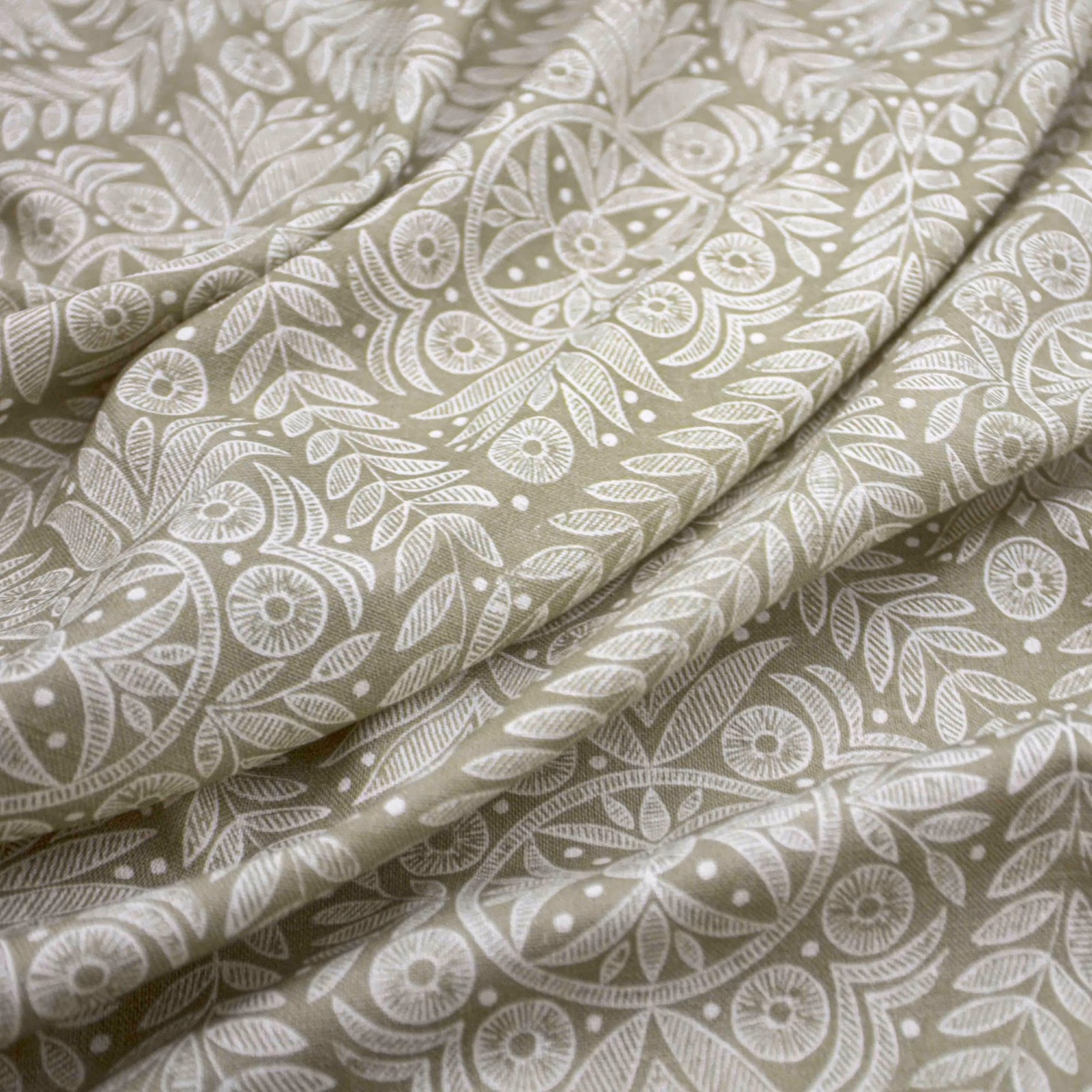 Putty taupe fabric with white leafy botanical, paisley and flower motifs in soft folds