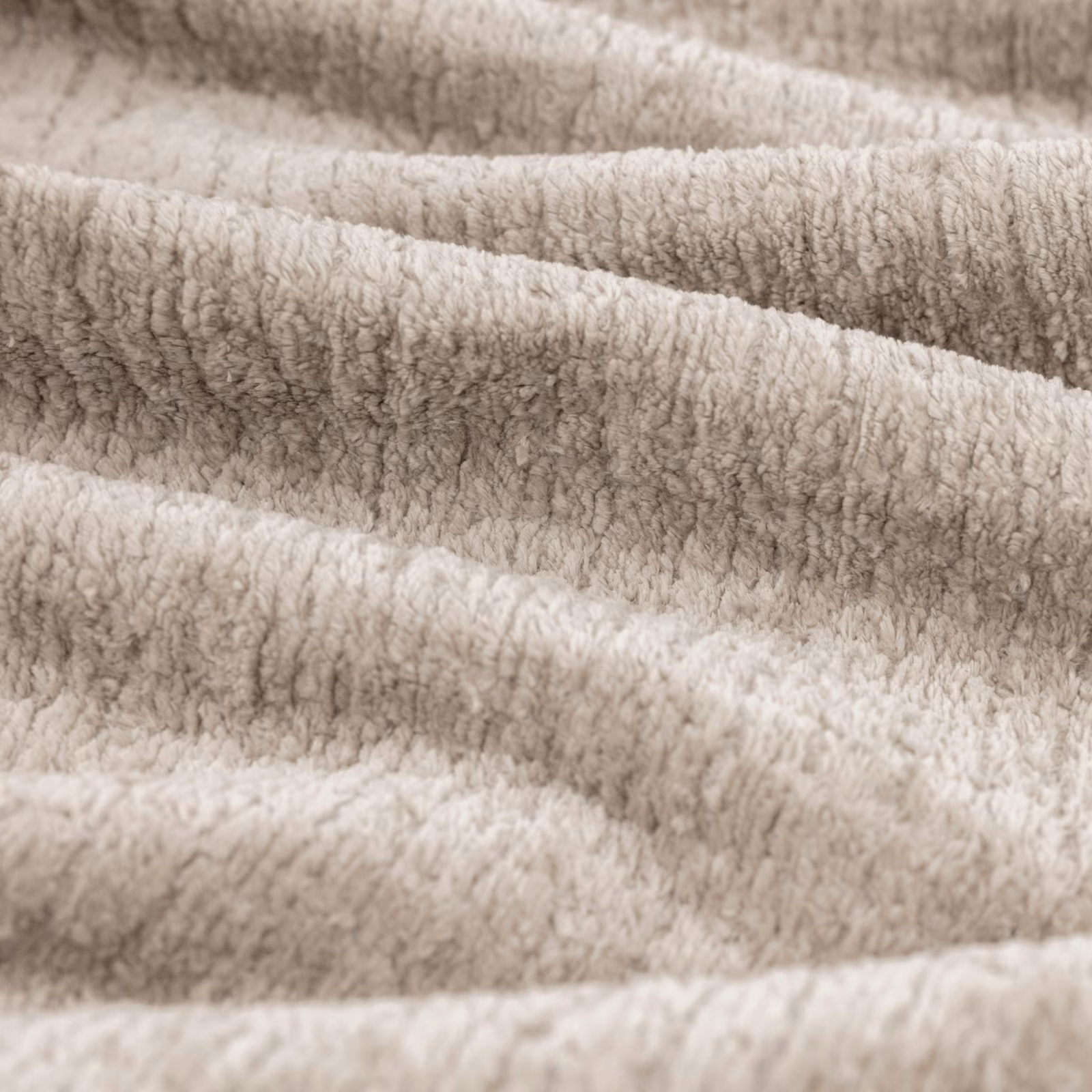 Warm fawn-taupe plush fabric with softly rippled, nubby pile in close-up