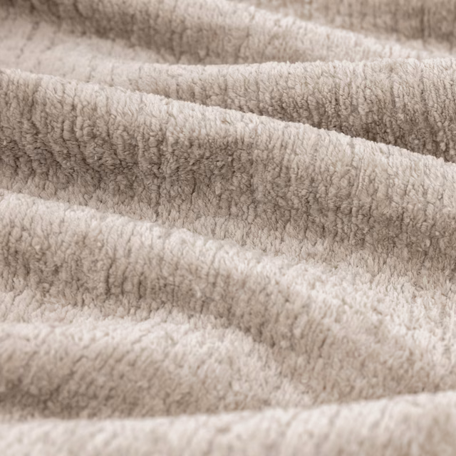 Warm fawn-taupe plush fabric with softly rippled, nubby pile in close-up