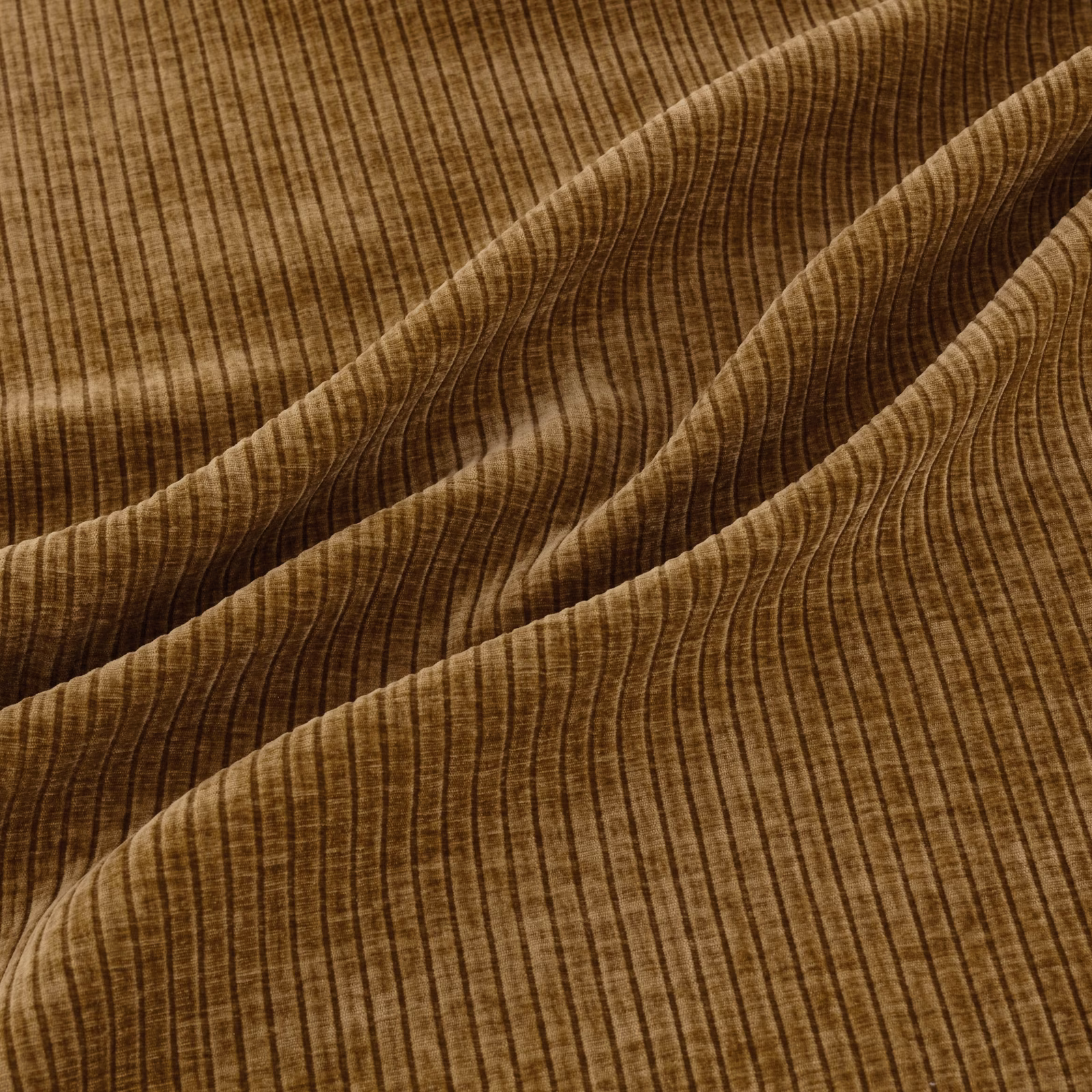 Warm curry-brown ribbed fabric draped in folds with darker vertical lines