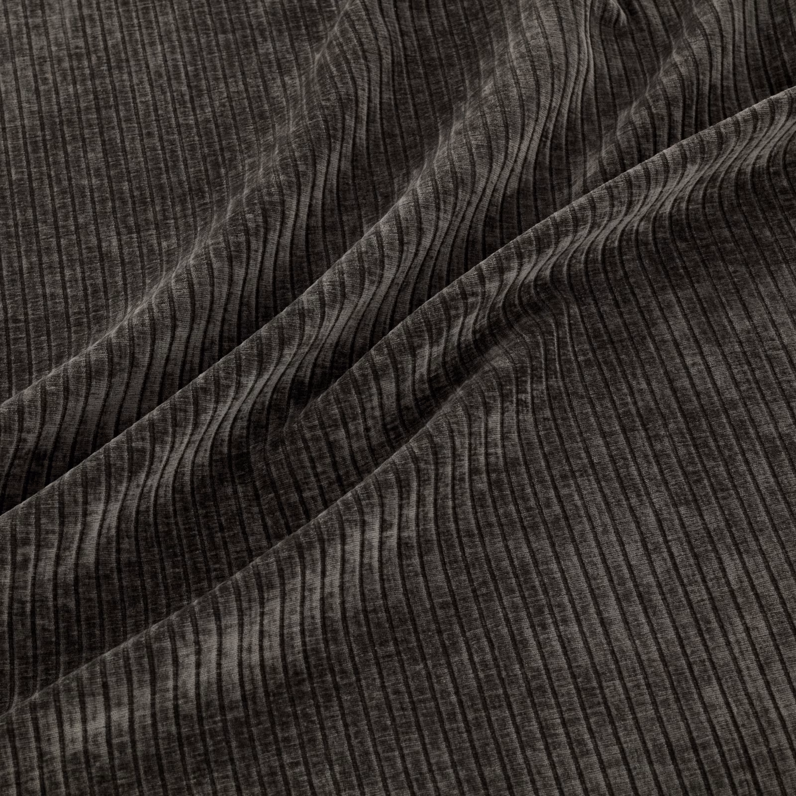 Close-up of dark graphite fabric with rippling vertical ribs and charcoal highlights