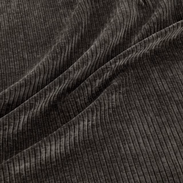 Close-up of dark graphite fabric with rippling vertical ribs and charcoal highlights