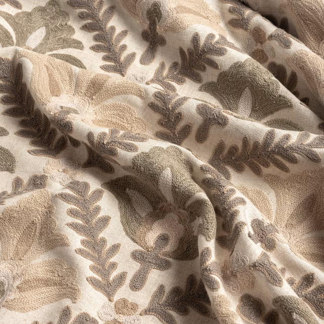 Warm parchment fabric with taupe leafy branches and rounded floral motifs in soft folds