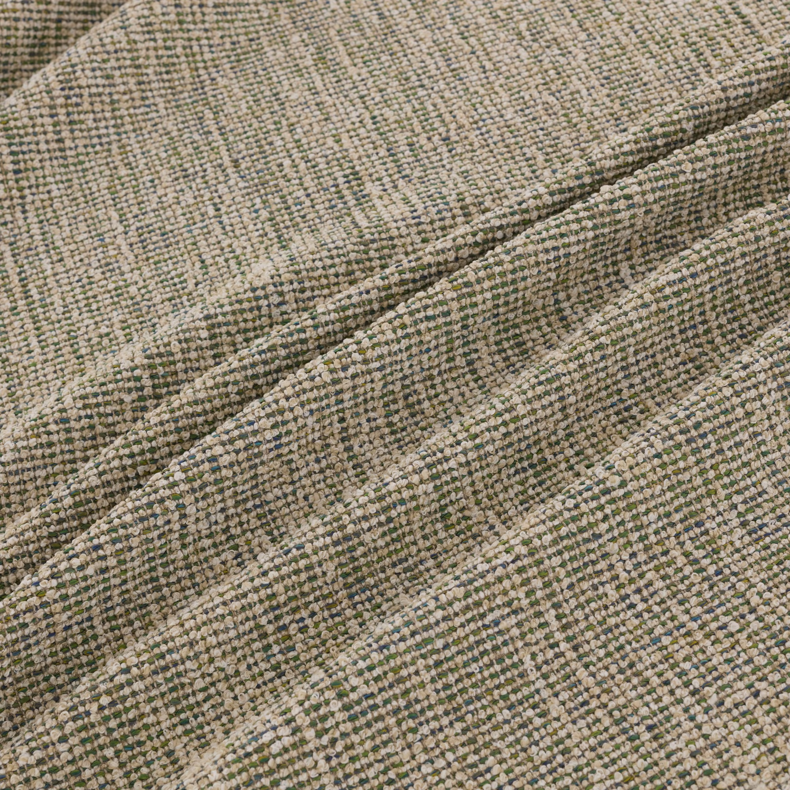 Muted sage-green, beige and grey woven textile shown in softly rippled folds